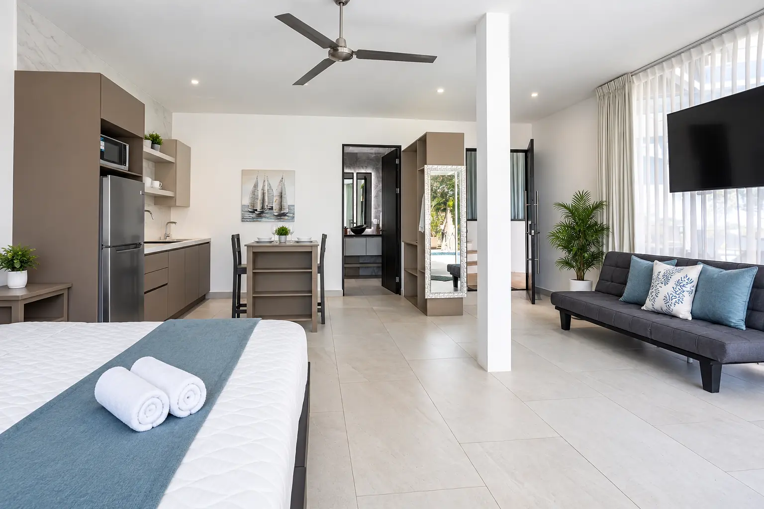 Open-plan Suite 2 interior with bed, kitchenette and lounge at Hotel VOS