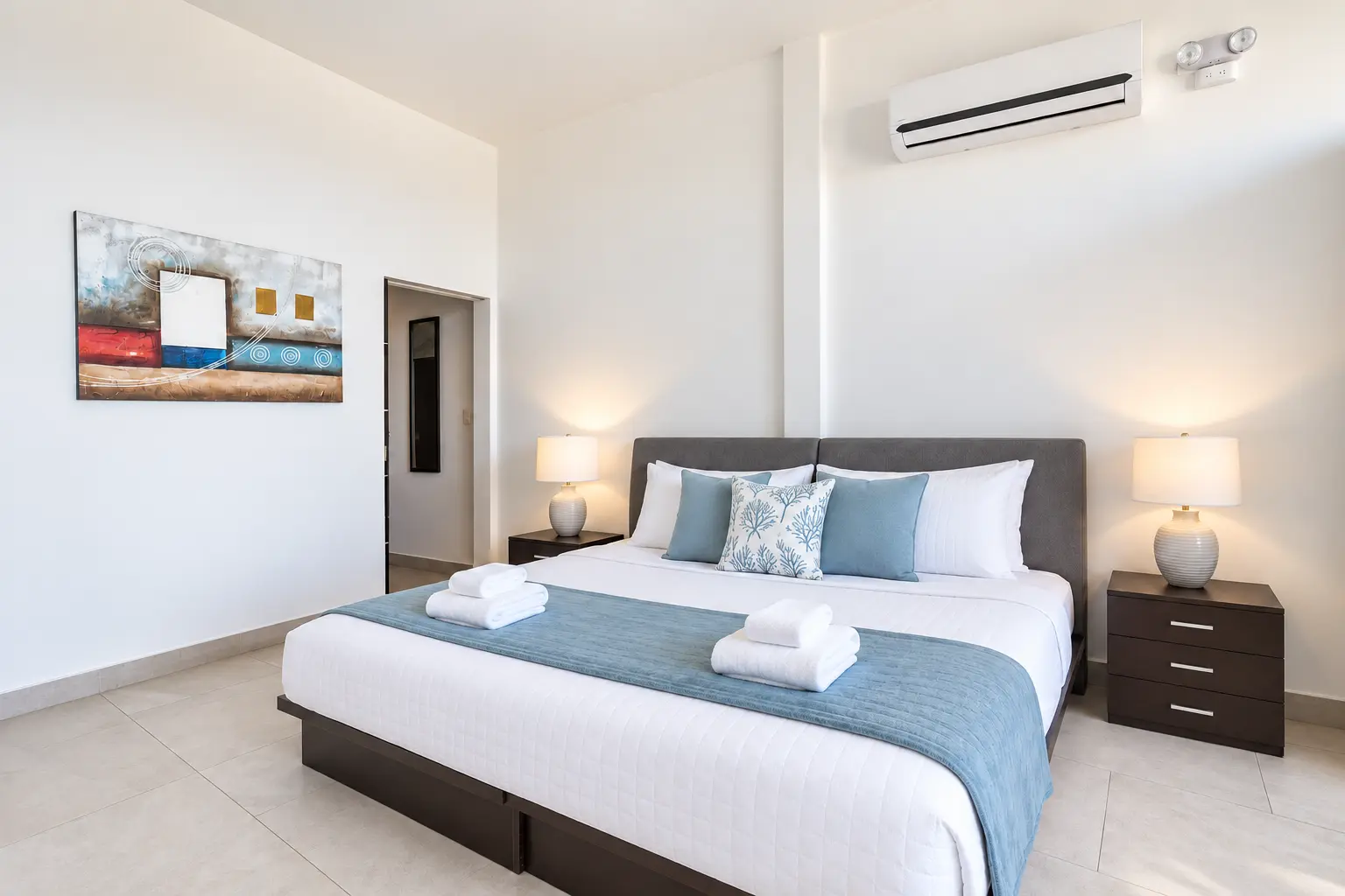 Suite 9 king bedroom with white bedding and ocean-blue runner